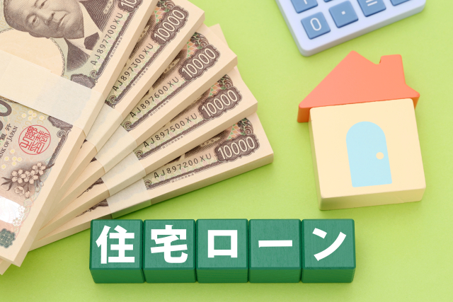Stacks of Japanese yen banknotes, a colorful house model, and a calculator on a green background, illustrating mortgage loan borrowing and home purchase funding.