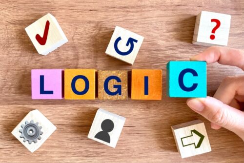 hand-arranging-colorful-wooden-blocks-spelling-the-word-logic-on-a-table-representing-the-foundational-rules-and-theories-of-english-learning