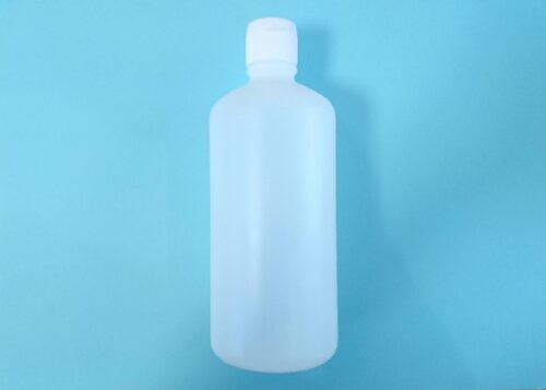 a-white-translucent-plastic-bottle-with-a-cap-centered-on-a-light-blue-background